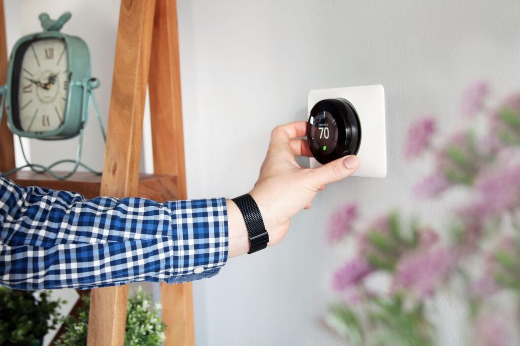 Man changes thermostat temperature inside during the Summer