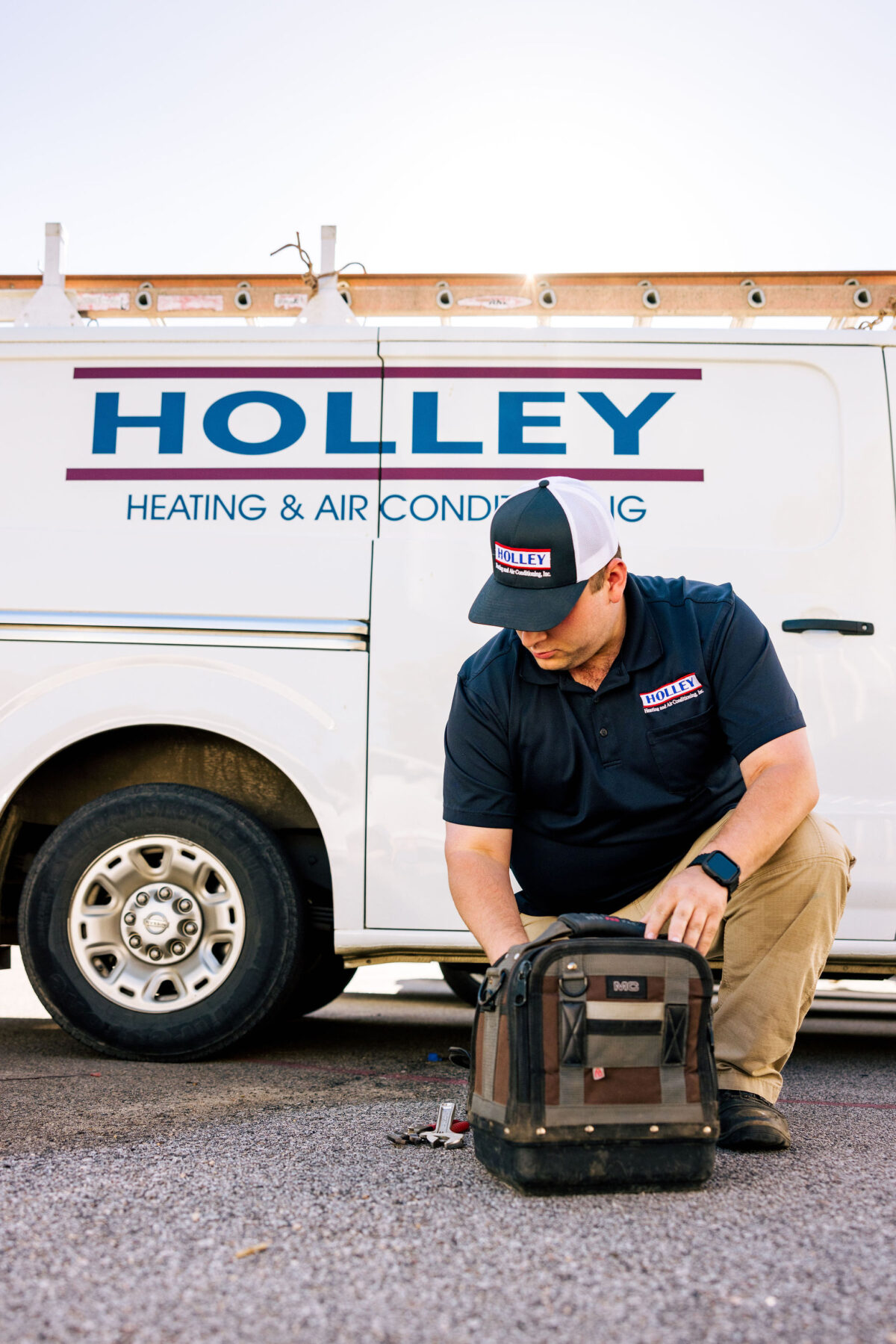 A Holley Heating and Air professional diagnosing an AC issue